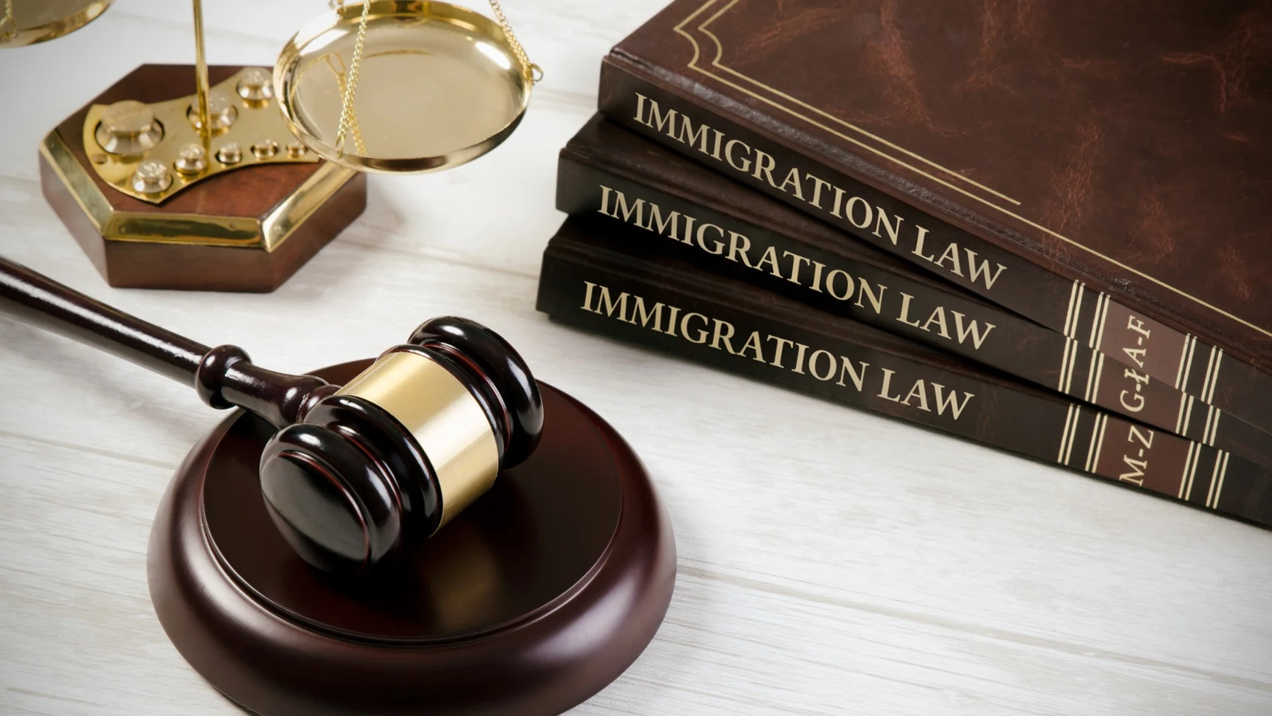 Immigration law books and gold scales